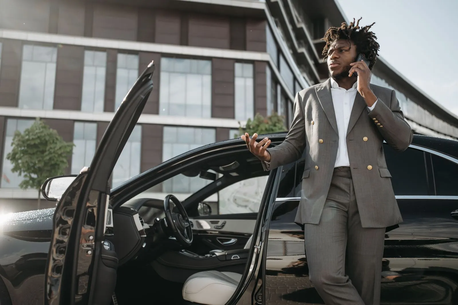 Chauffeur at the rear door of a first-class sedan