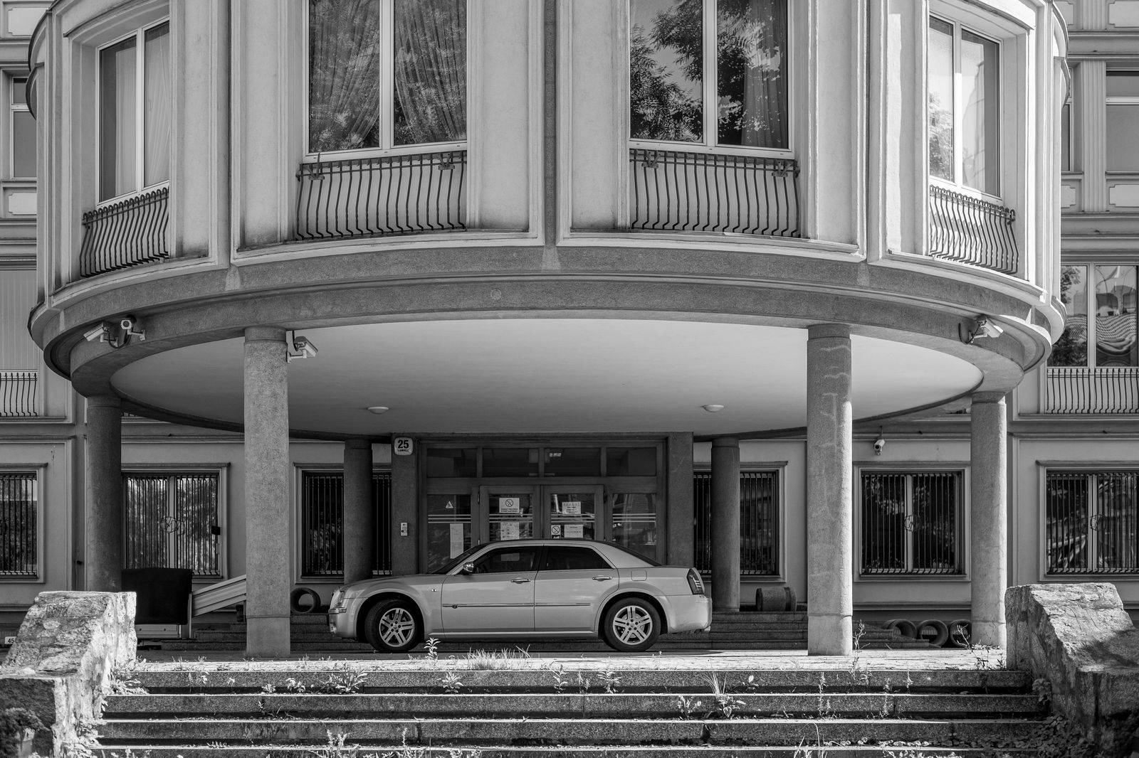 The black car: unmarked, detailed, at the kerb fifteen minutes early